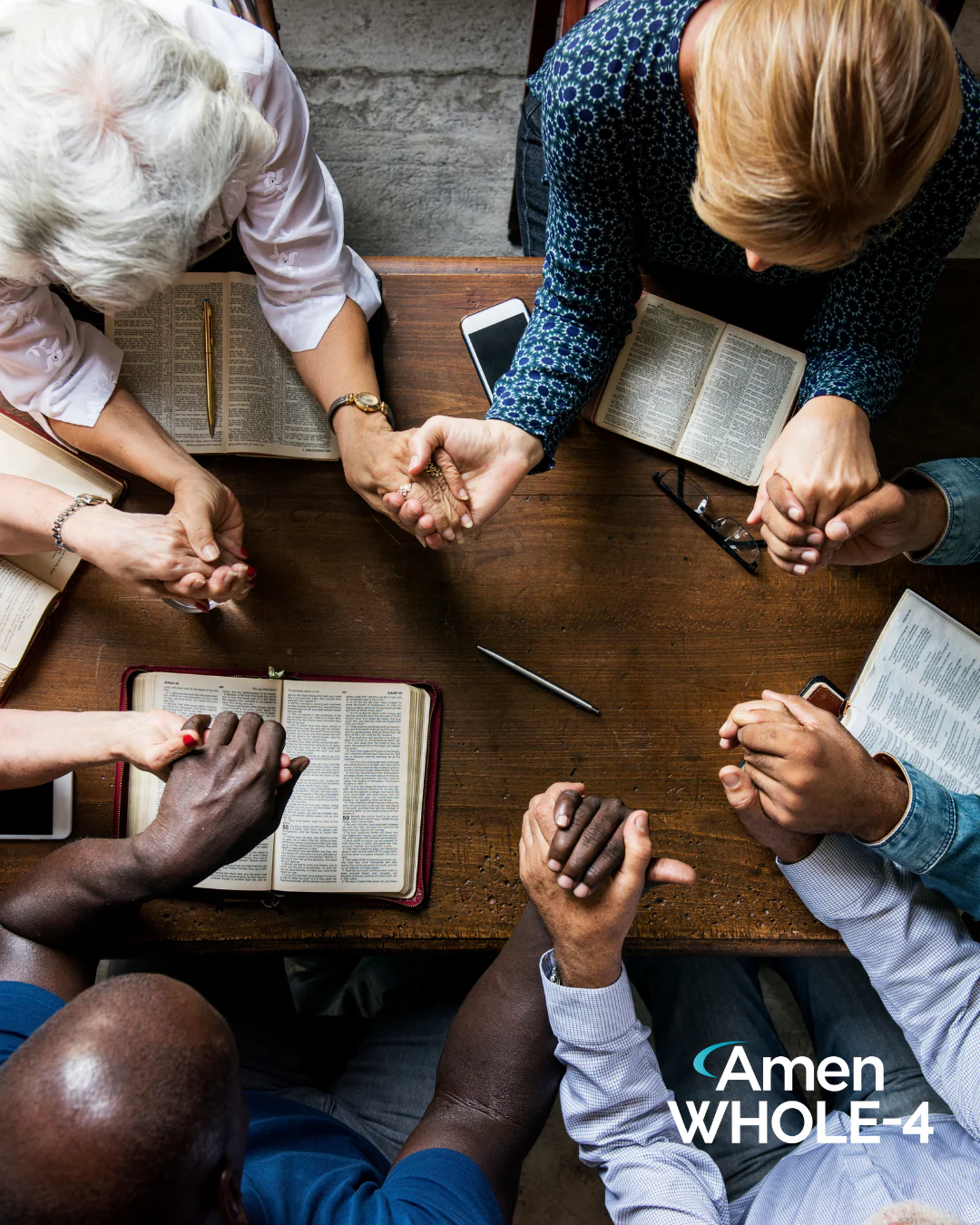 A group gathered around a table in prayer